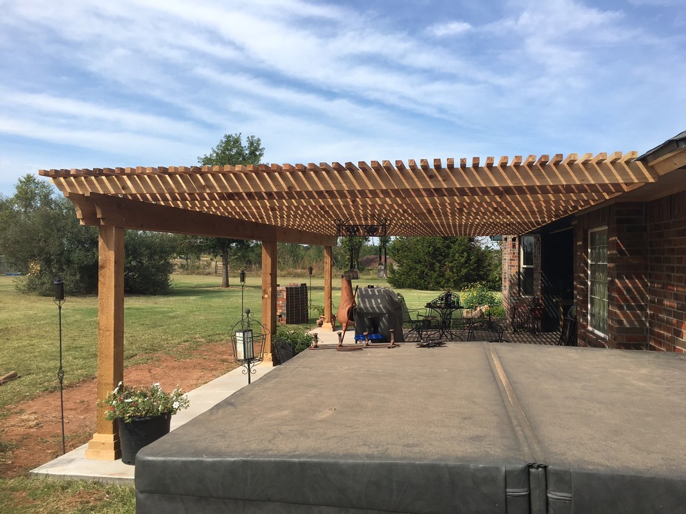 Large traditional backyard patio in Oklahoma City with a pergola and concrete pavers.