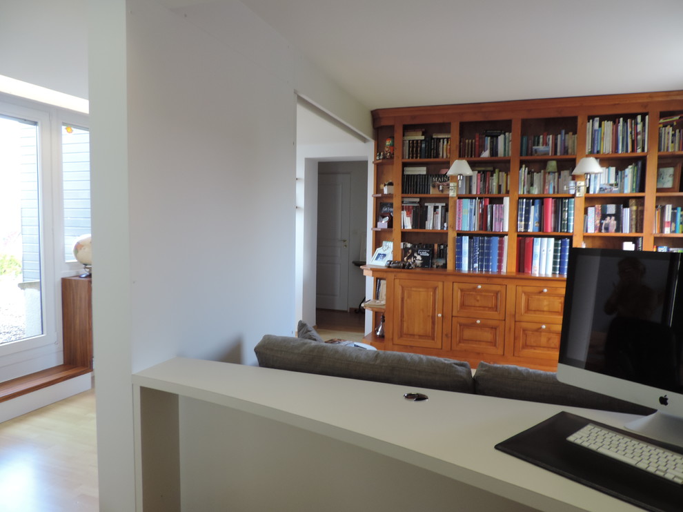 Exemple d'un petit bureau éclectique avec une bibliothèque ou un coin lecture, un mur blanc, parquet clair, aucune cheminée et un bureau intégré.