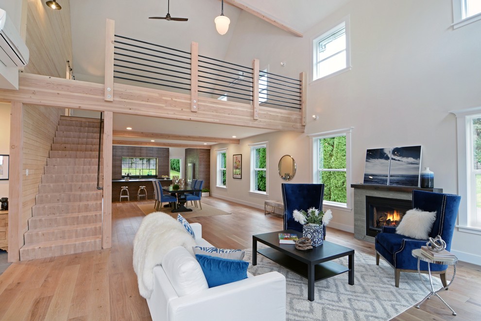 Contemporary formal open concept living room in Seattle with white walls, light hardwood floors and a standard fireplace.
