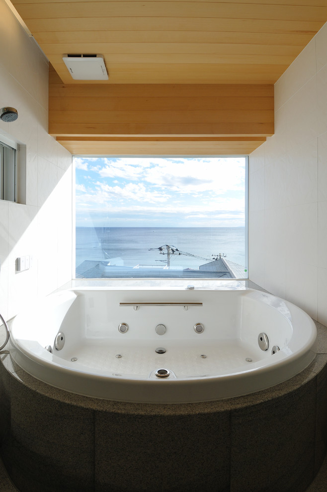 Design ideas for an asian bathroom in Tokyo with a corner tub and white walls.