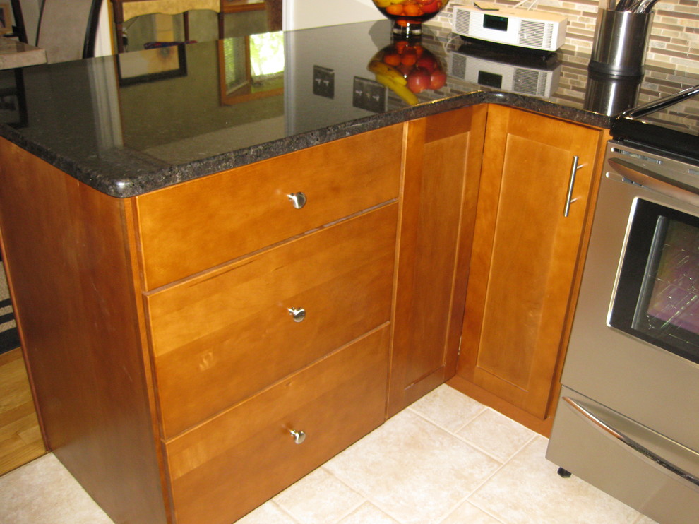 Eat-in kitchen - transitional u-shaped travertine floor and beige floor eat-in kitchen idea in Boston with an undermount sink, medium tone wood cabinets, granite countertops, stainless steel appliances, a peninsula, shaker cabinets, brown backsplash, matchstick tile backsplash and black countertops