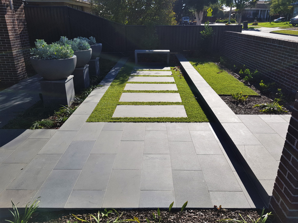 Mid-sized modern front yard partial sun formal garden in Melbourne with with flowerbed and natural stone pavers for summer.