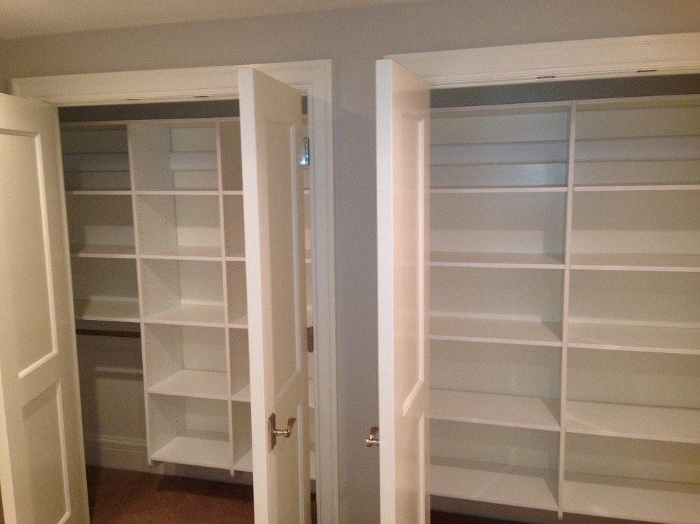Inspiration for a mid-sized traditional gender-neutral built-in wardrobe in Salt Lake City with flat-panel cabinets, white cabinets, carpet and beige floor.