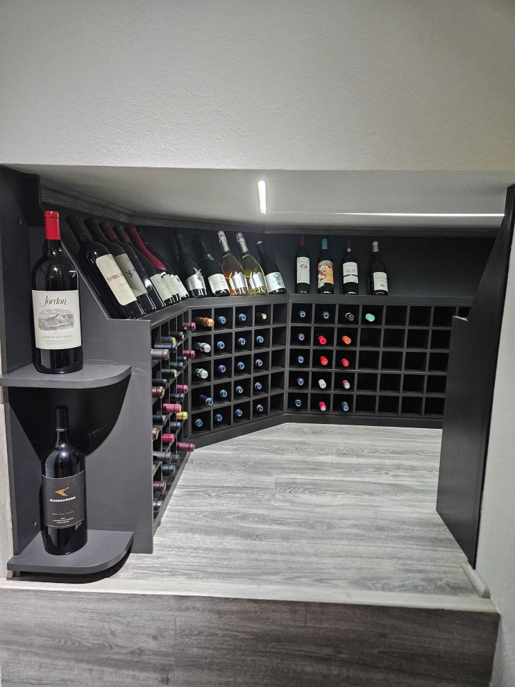 Inspiration for a small industrial wine cellar in San Francisco with laminate floors, storage racks and grey floor.