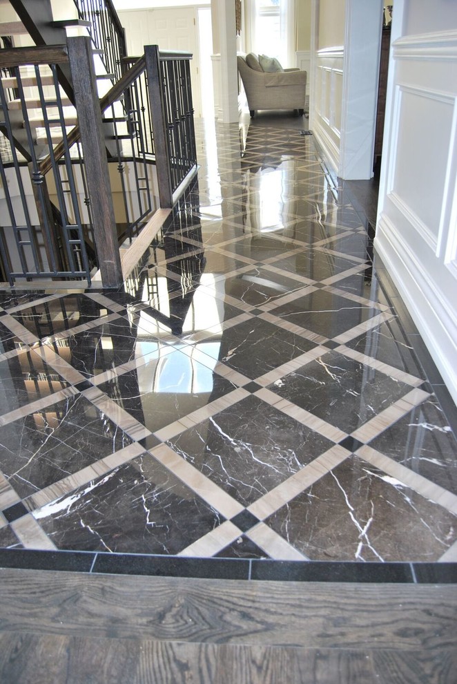 Design ideas for a traditional foyer in Toronto with beige walls, marble floors and black floor.