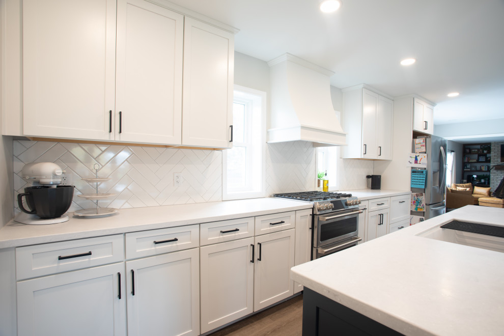 Transitional vinyl floor kitchen photo with shaker cabinets, white cabinets, quartz countertops, white backsplash, porcelain backsplash, stainless steel appliances and white countertops