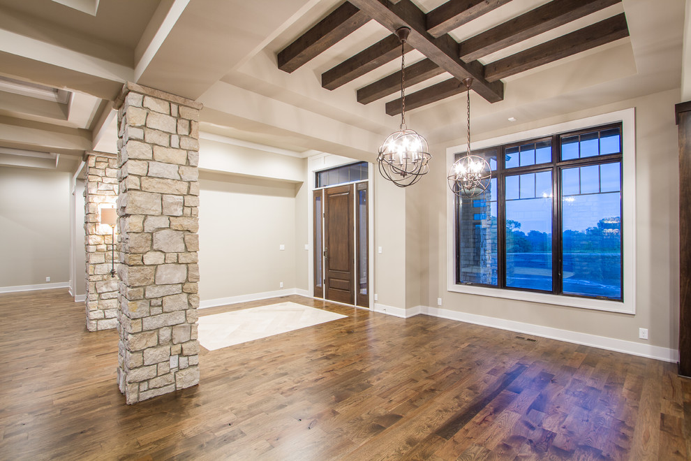 Foyer - large transitional medium tone wood floor foyer idea in Omaha with beige walls and a dark wood front door