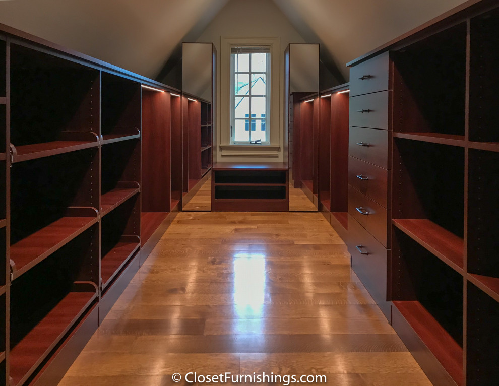 This is an example of a mid-sized modern gender-neutral walk-in wardrobe in Chicago with flat-panel cabinets, red cabinets and dark hardwood floors.