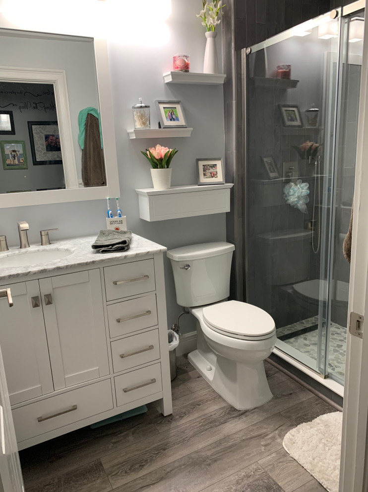 Photo of a small classic shower room bathroom in Miami with shaker cabinets, white cabinets, an alcove shower, a one-piece toilet, grey tiles, metro tiles, grey walls, vinyl flooring, a submerged sink, marble worktops, multi-coloured floors, a sliding door, multi-coloured worktops, a shower bench, a single sink and a built in vanity unit.
