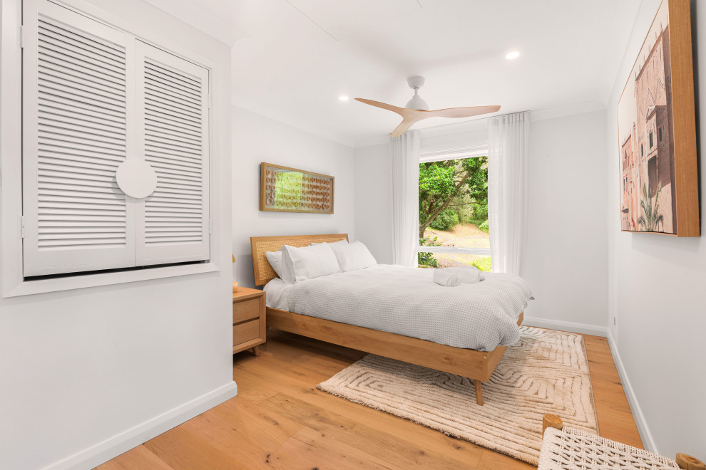 シドニーにある広いコンテンポラリースタイルのおしゃれな客用寝室 (白い壁、淡色無垢フローリング) のインテリア