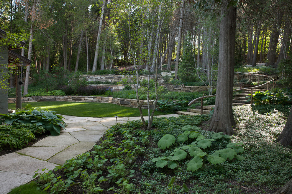 Design ideas for a large rustic partial sun front yard stone retaining wall landscape for summer.