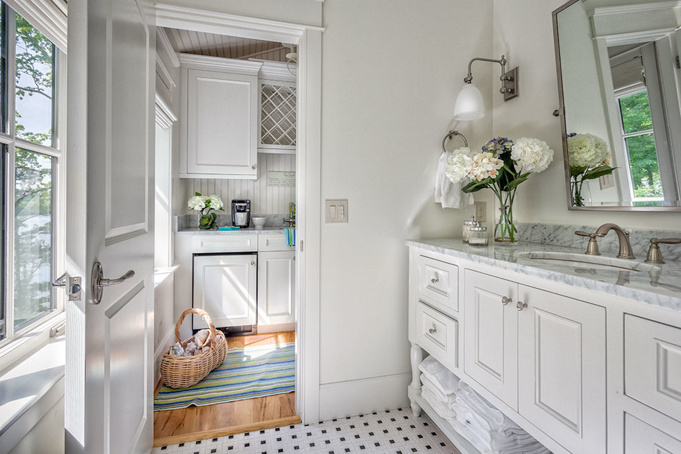 Photo of a mid-sized transitional bathroom in Other with beaded inset cabinets, white cabinets, white walls, porcelain floors, an undermount sink, marble benchtops and a laundry.