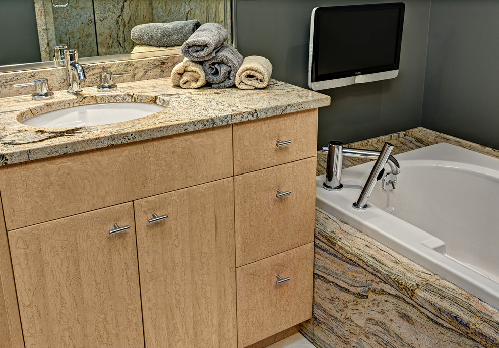 Inspiration for a mid-sized contemporary master bathroom in Minneapolis with an undermount sink, flat-panel cabinets, light wood cabinets, granite benchtops, a drop-in tub, beige tile, porcelain tile, grey walls and porcelain floors.