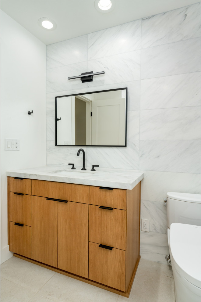 Inspiration for a small contemporary kids bathroom in Orange County with flat-panel cabinets, medium wood cabinets, a drop-in tub, a shower/bathtub combo, a one-piece toilet, travertine floors, an undermount sink, engineered quartz benchtops, beige floor, a sliding shower screen, a single vanity and a built-in vanity.