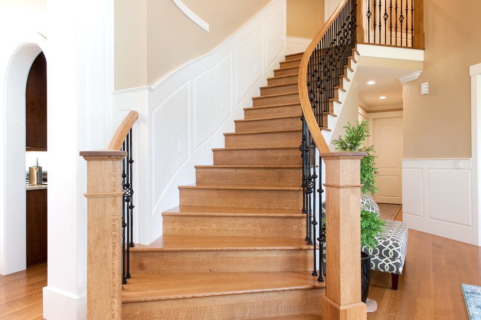 This is an example of a mid-sized traditional wood curved staircase in Seattle with metal risers.