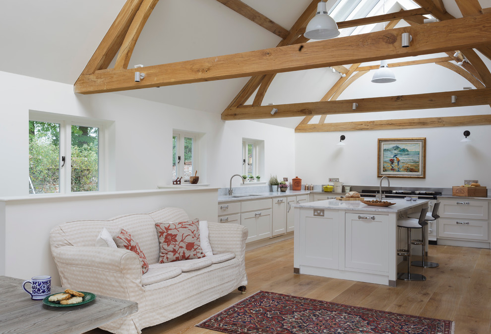 Transitional u-shaped open plan kitchen in Wiltshire with shaker cabinets, white cabinets and white appliances.