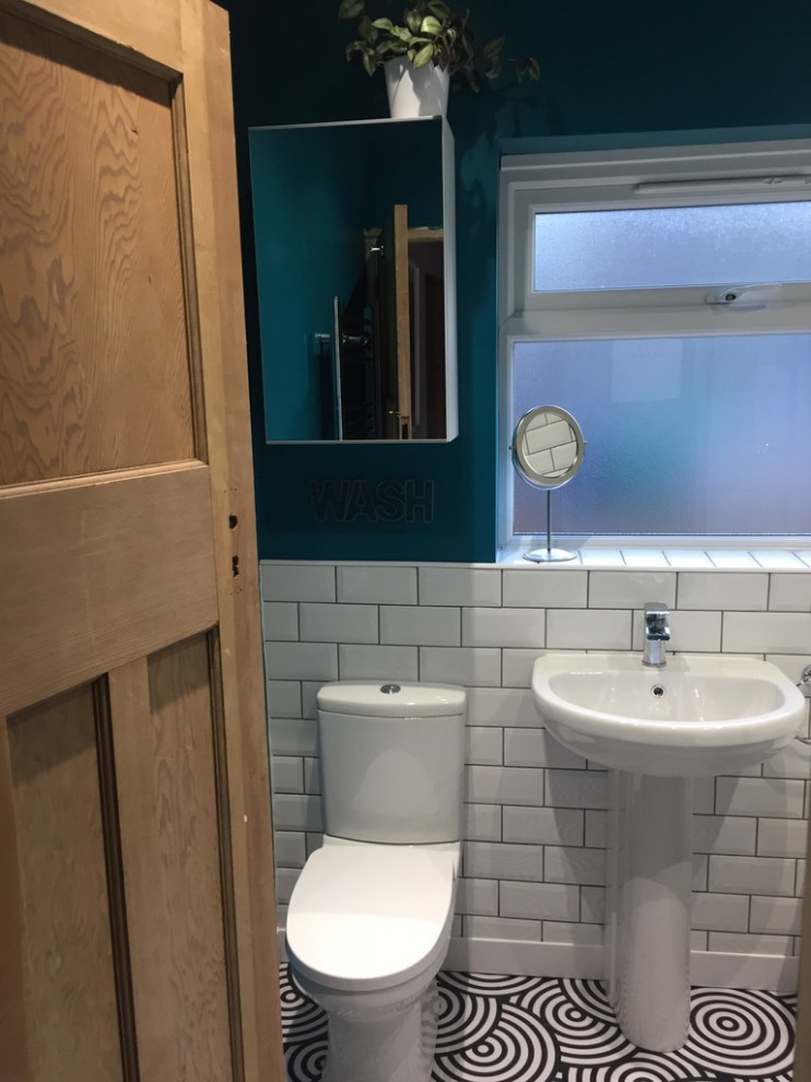 Design ideas for a small modern cloakroom in Other with a one-piece toilet, white tiles, metro tiles, green walls, lino flooring, a pedestal sink and black floors.