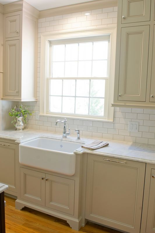 Example of a transitional medium tone wood floor kitchen design in Atlanta with a farmhouse sink, beige cabinets, quartzite countertops and an island