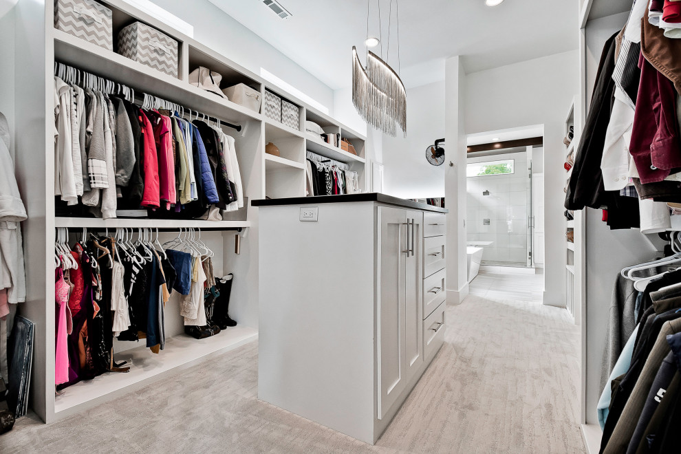 Inspiration for a large modern gender-neutral walk-in wardrobe in Other with recessed-panel cabinets, white cabinets, carpet and grey floor.