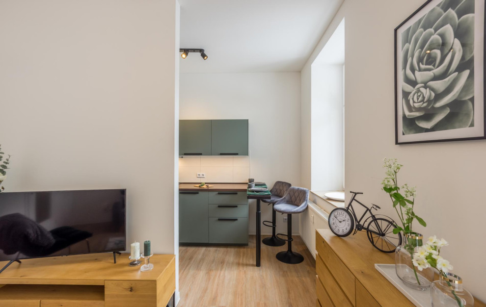 На фото: маленькая открытая гостиная комната в стиле модернизм с белыми стенами, светлым паркетным полом, отдельно стоящим телевизором, коричневым полом, потолком с обоями и обоями на стенах для на участке и в саду