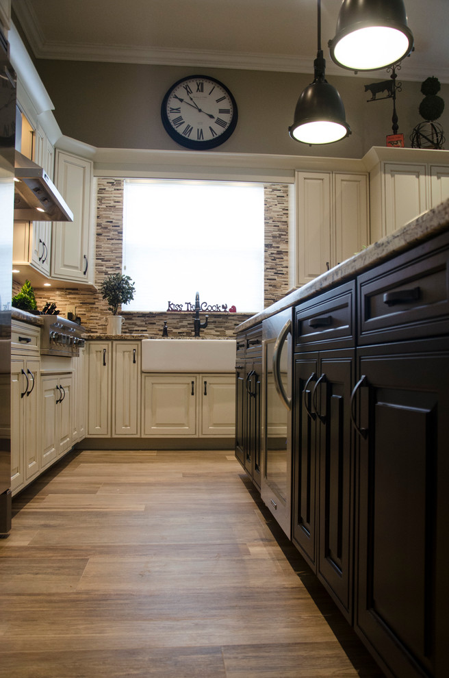 Example of a large transitional l-shaped porcelain tile open concept kitchen design in Miami with a farmhouse sink, raised-panel cabinets, white cabinets, granite countertops, multicolored backsplash, mosaic tile backsplash, stainless steel appliances and an island