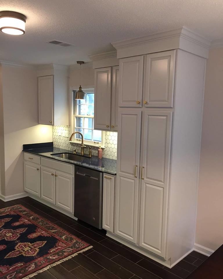 Inspiration for a small eclectic galley porcelain tile and brown floor enclosed kitchen remodel with an undermount sink, raised-panel cabinets, white cabinets, quartz countertops, white backsplash, marble backsplash, stainless steel appliances, no island and blue countertops