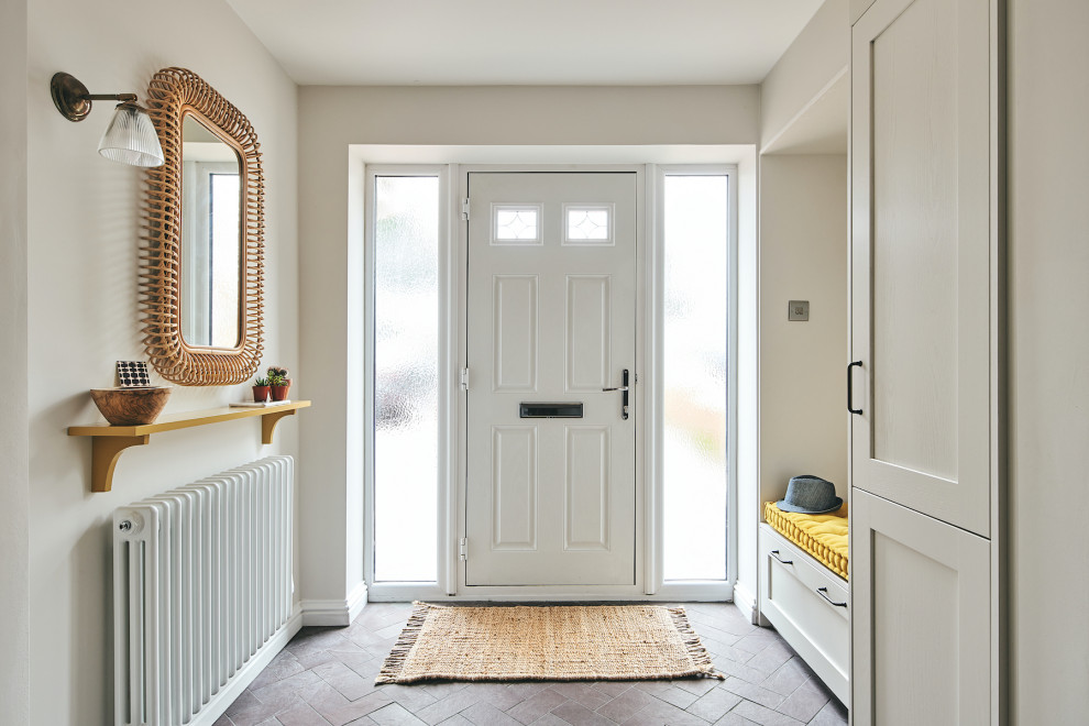 Inspiration pour une entrée traditionnelle de taille moyenne avec un couloir, un mur blanc, un sol en ardoise, une porte simple, une porte blanche et un sol violet.
