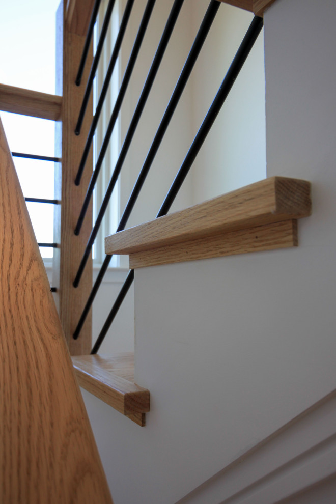 Photo of a mid-sized contemporary wood floating staircase in DC Metro with painted wood risers, mixed railing and planked wall panelling.