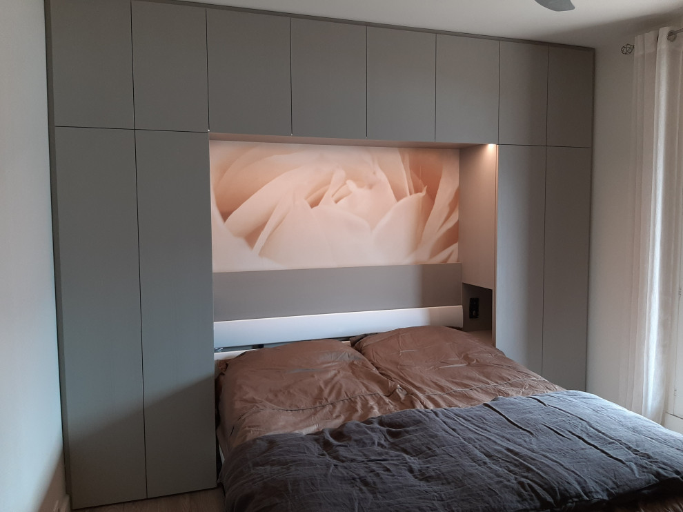 Imagen de habitación de invitados gris y blanca contemporánea pequeña con paredes grises, suelo de madera clara y suelo gris