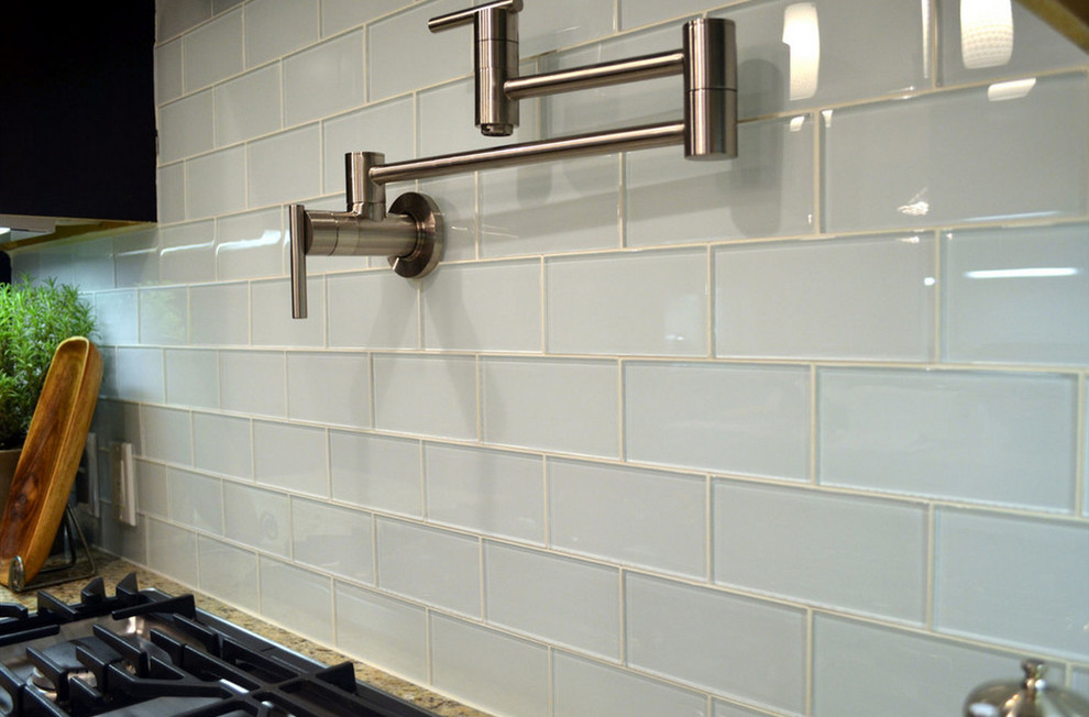 Kitchen - transitional medium tone wood floor kitchen idea with raised-panel cabinets, white cabinets, granite countertops, blue backsplash, glass tile backsplash and stainless steel appliances