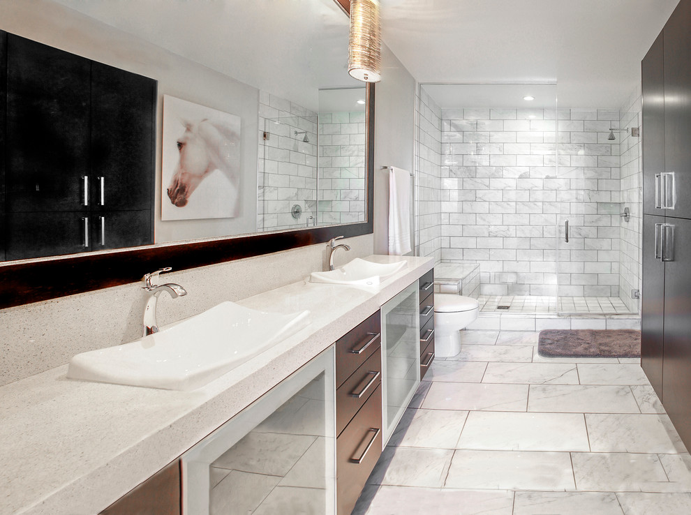 Example of a trendy white tile alcove shower design in Las Vegas with a drop-in sink, flat-panel cabinets, dark wood cabinets, white walls and white countertops