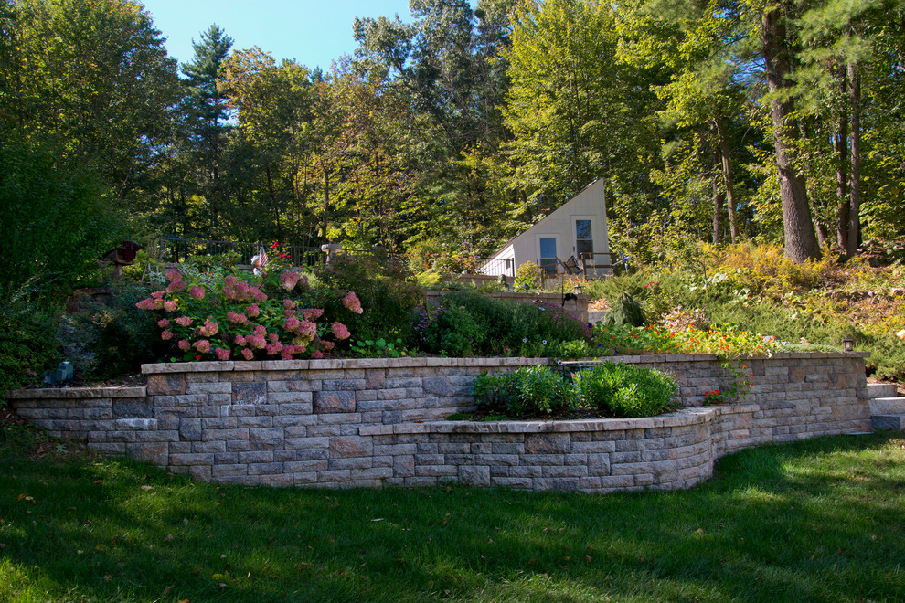 Photo of a rustic front yard concrete paver driveway in Boston.