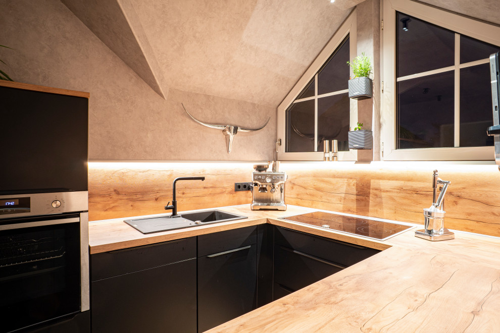 Moderne Schmale Küche mit schwarzen Schränken, Arbeitsplatte aus Holz, Küchenrückwand in Braun, Rückwand aus Holz, brauner Arbeitsplatte und hellem Holzboden in Dortmund