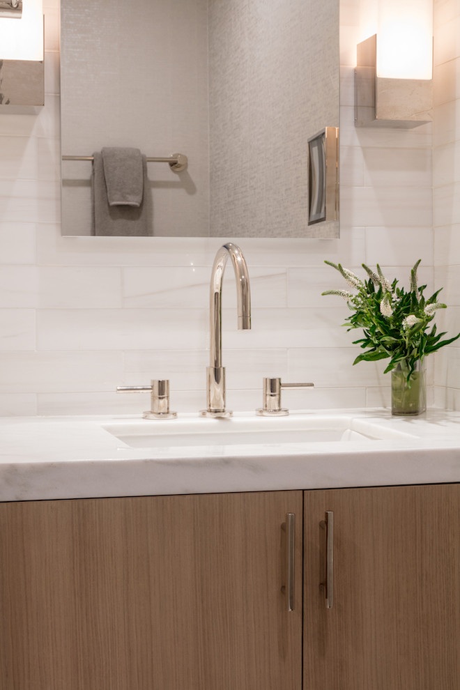 This is an example of a small contemporary master bathroom in Boston with flat-panel cabinets, light wood cabinets, a drop-in sink, marble benchtops and white benchtops.