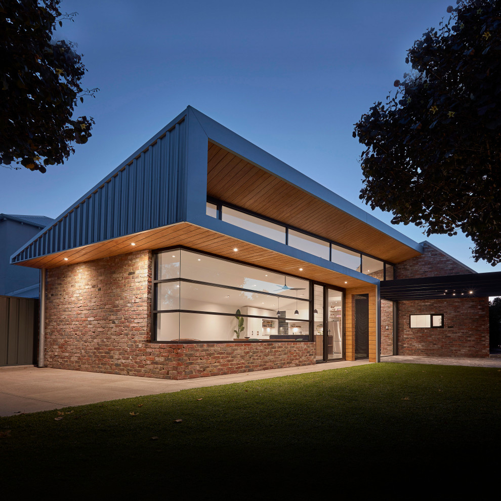 Idée de décoration pour une petite façade de maison multicolore minimaliste en brique de plain-pied avec un toit en appentis, un toit en métal et un toit gris.