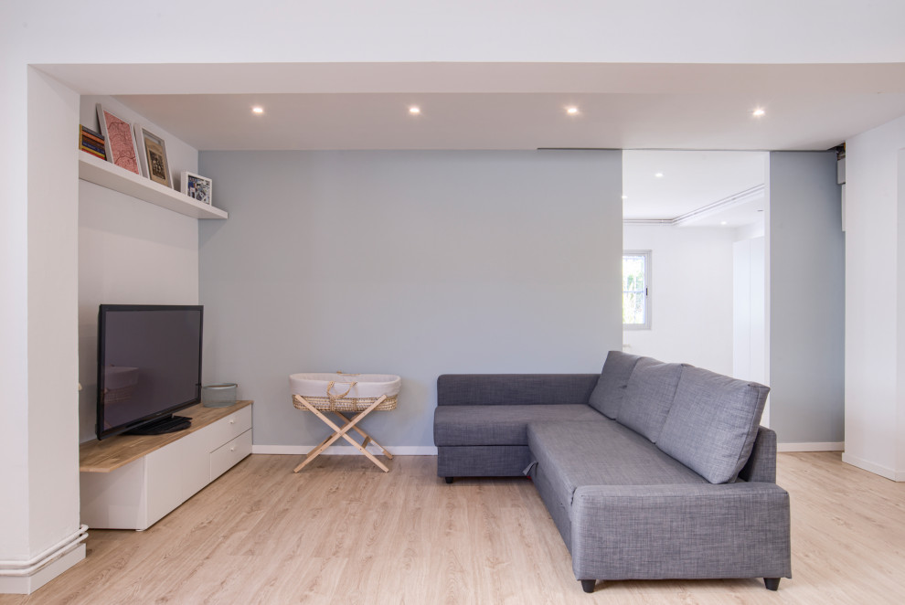 Imagen de salón abierto y gris y blanco minimalista de tamaño medio con paredes grises, suelo de madera en tonos medios, televisor colgado en la pared y suelo marrón
