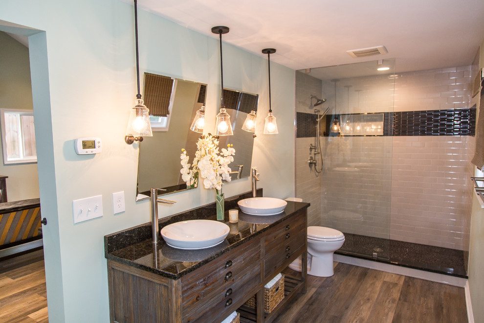 Mid-sized transitional 3/4 bathroom in Other with furniture-like cabinets, distressed cabinets, a shower/bathtub combo, white tile, ceramic tile, grey walls, vinyl floors, a vessel sink, brown floor, an open shower and granite benchtops.