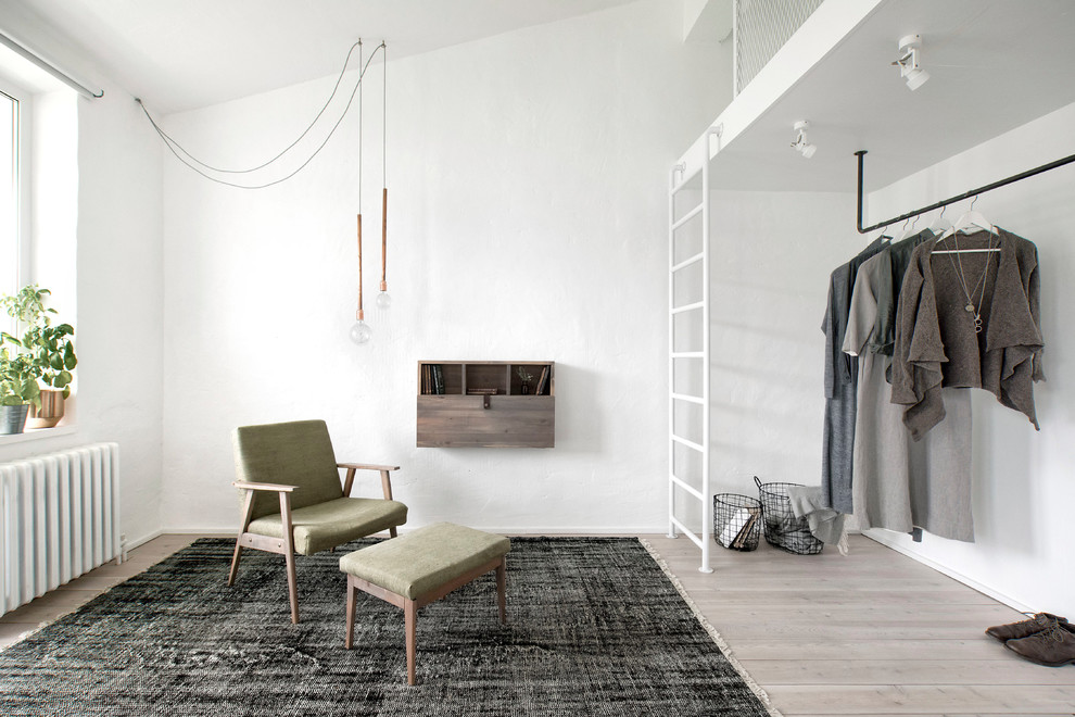 Design ideas for a small industrial gender-neutral walk-in wardrobe in Saint Petersburg with beige floor and light hardwood floors.