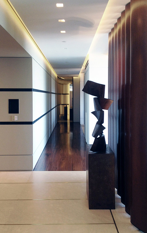 Inspiration for a mid-sized contemporary hallway in Los Angeles with beige walls and dark hardwood floors.