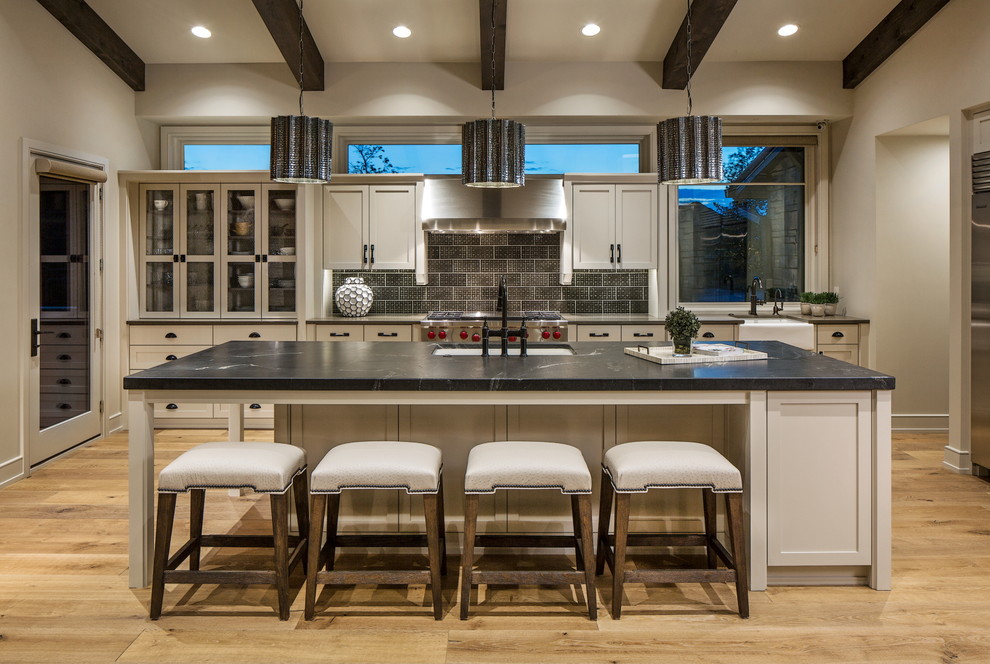 Inspiration for a transitional kitchen in Omaha with an undermount sink, shaker cabinets, beige cabinets, metallic splashback, stainless steel appliances, light hardwood floors and with island.