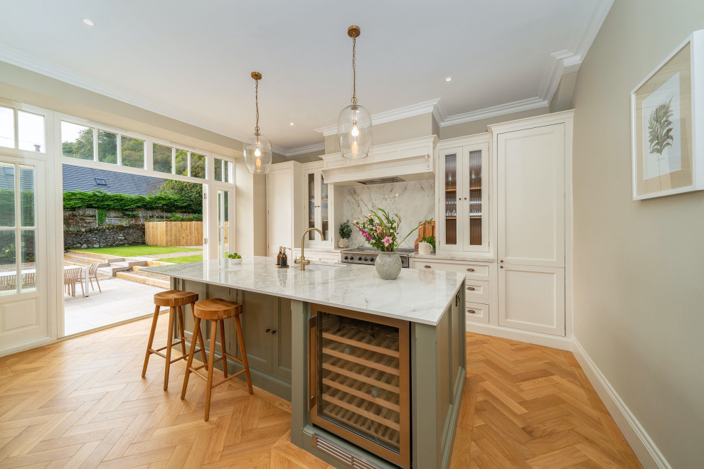 Photo of a large classic kitchen/diner in Other with beaded cabinets, white cabinets, white splashback, an island, brown floors and white worktops.