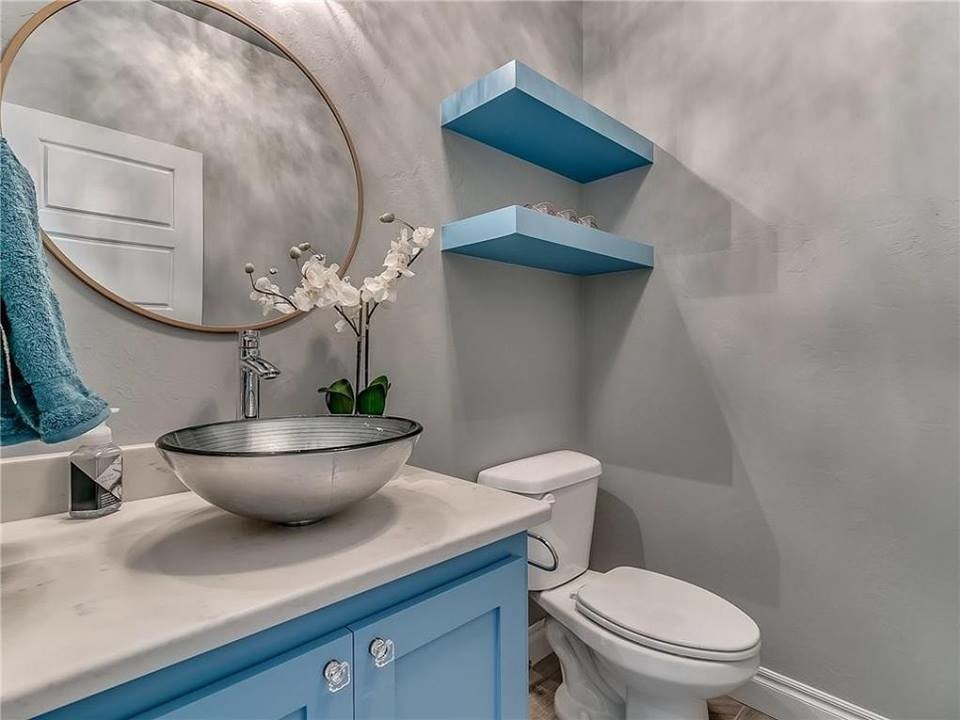 This is an example of a mid-sized transitional powder room in Oklahoma City with shaker cabinets, blue cabinets, a two-piece toilet, grey walls, a vessel sink, engineered quartz benchtops and white benchtops.