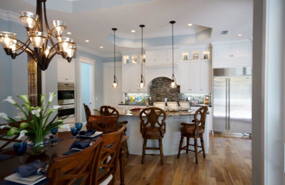 Example of a transitional single-wall dark wood floor eat-in kitchen design in Tampa with raised-panel cabinets, white cabinets, granite countertops, multicolored backsplash, matchstick tile backsplash, stainless steel appliances and an island