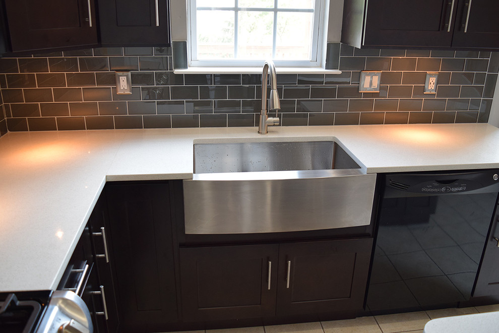 Inspiration for a mid-sized contemporary l-shaped eat-in kitchen in DC Metro with a farmhouse sink, shaker cabinets, dark wood cabinets, quartz benchtops, grey splashback, glass tile splashback, stainless steel appliances, porcelain floors, with island and beige floor.