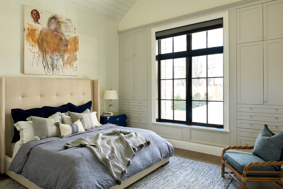 This is an example of a transitional bedroom in Denver with beige walls, medium hardwood floors and brown floor.