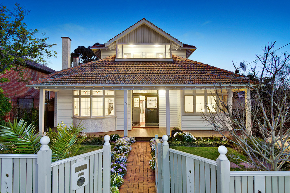 Inspiration for a small traditional two-storey white exterior in Melbourne with wood siding and a hip roof.