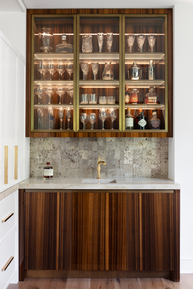 Transitional single-wall wet bar in Baltimore with an integrated sink, flat-panel cabinets, medium wood cabinets, grey splashback, medium hardwood floors, brown floor and white benchtop.