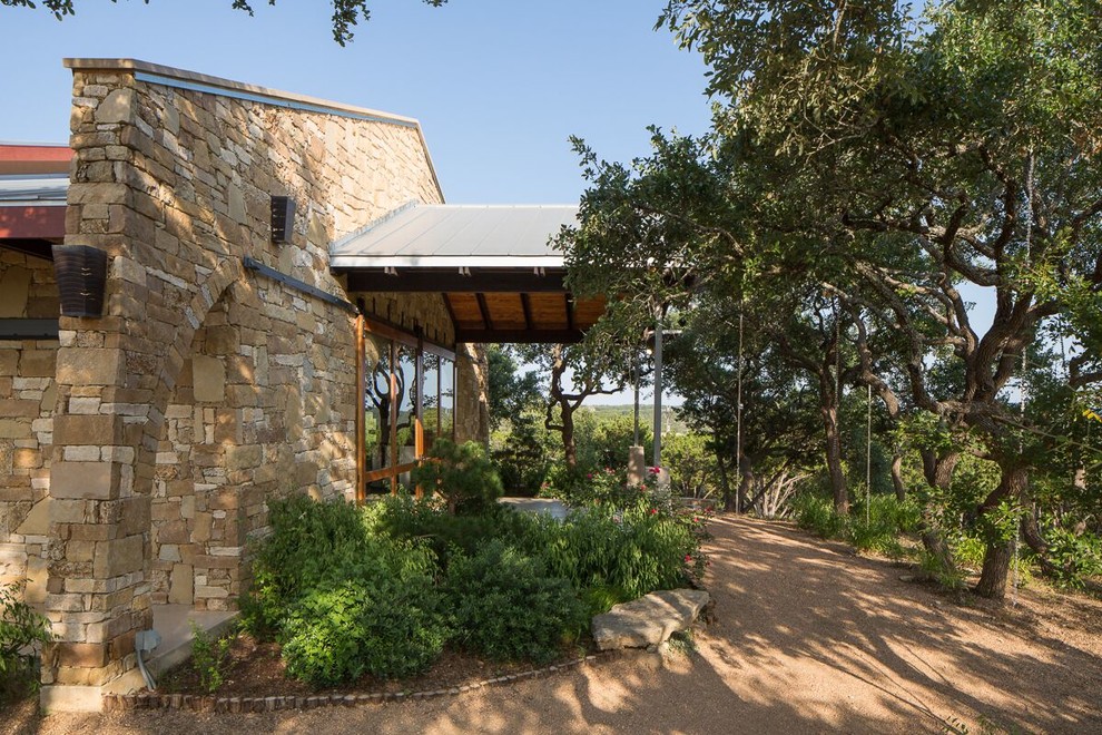 Large industrial one-storey brown exterior in Austin with stone veneer and a gable roof.
