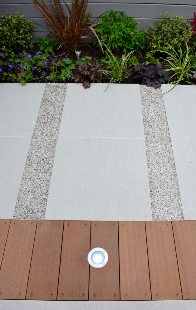 This is an example of a small contemporary back partial sun garden for summer in London.