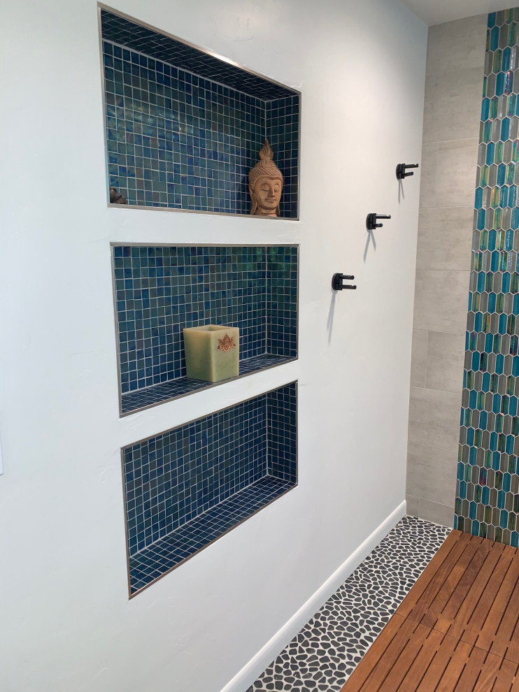 Источник вдохновения для домашнего уюта: главная ванная комната среднего размера в стиле модернизм с фасадами в стиле шейкер, серыми фасадами, душем без бортиков, унитазом-моноблоком, синей плиткой, стеклянной плиткой, серыми стенами, полом из галечной плитки, врезной раковиной, столешницей из искусственного кварца, серым полом, душем с распашными дверями, серой столешницей, нишей, тумбой под две раковины и встроенной тумбой